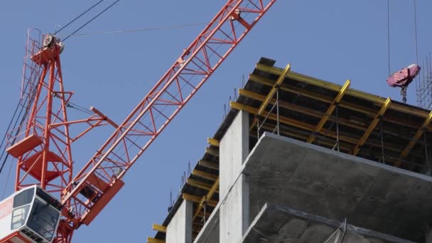 Guindastes de construção mover materiais de construção e trabalho na construção de edifícios residenciais de vários andares — Vídeo de Stock