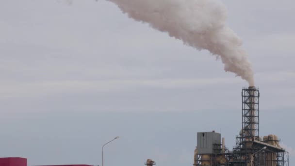 La zona industrial con una tubería de humo blanco grueso se vierte desde la tubería de fábrica en contraste con el sol. Contaminación del medio ambiente: una tubería con humo — Vídeos de Stock