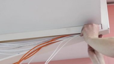 Elektrik tesisatı ve ekipman kurulumu. Uzman telleri çözer ve onları yumurtlamaya hazırlar.