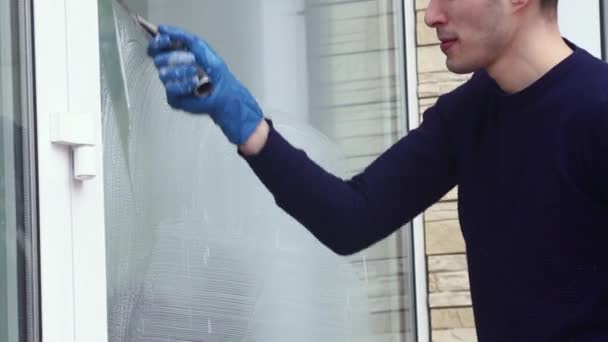 Un profesional de limpieza de ventanas jabones y exfoliantes una ventana limpia, trabajador de limpieza masculina. — Vídeos de Stock