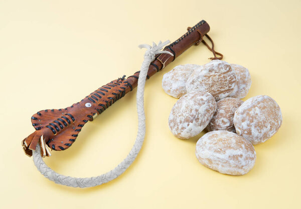 Whip and gingerbread on a neutral background. Threats and promises concept. Encouragement and punishment method knows as knut i pryanik or carrot-and-stick principle.