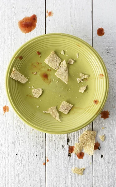 Dirty leftover plate of nachos with salsa — Stock Photo, Image