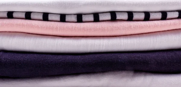 Stack of different colors clothes. Banner format.
