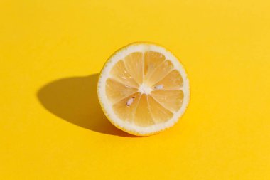 Sarı arka planda tohumları olan limon yarısı..
