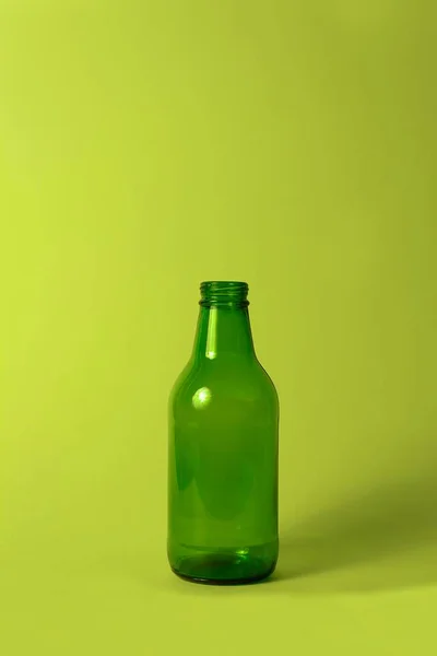 Темно-зеленая стеклянная бутылка на зеленом фоне . — стоковое фото