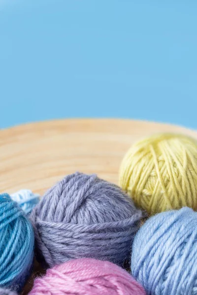 Boules de laine multicolores dans un bol. Fond bleu . — Photo