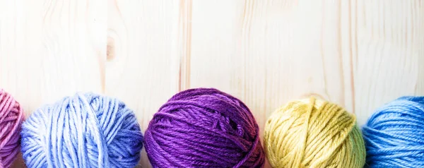Boules de laine multicolores sur fond en bois. Bannière . — Photo