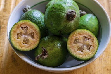 Fayjoa 'nın taze meyvesi masanın üzerindeki beyaz kasede.