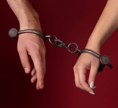 erkek ve kadın elleri kelepçeli.