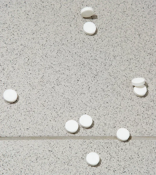 White tablets on the floor of tiles. — Stock Photo, Image