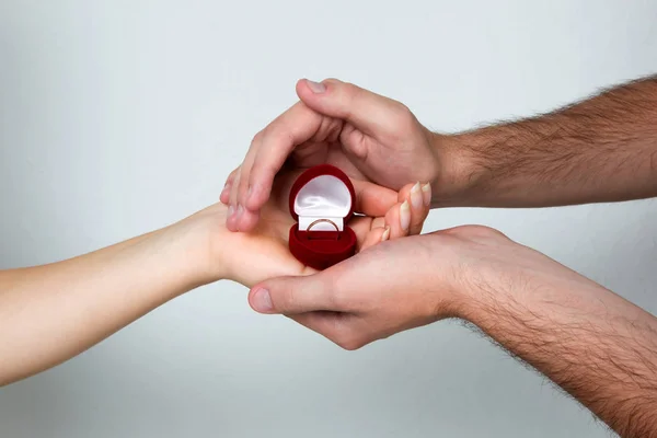 Female and male hands holding the ring box — Stock Photo, Image