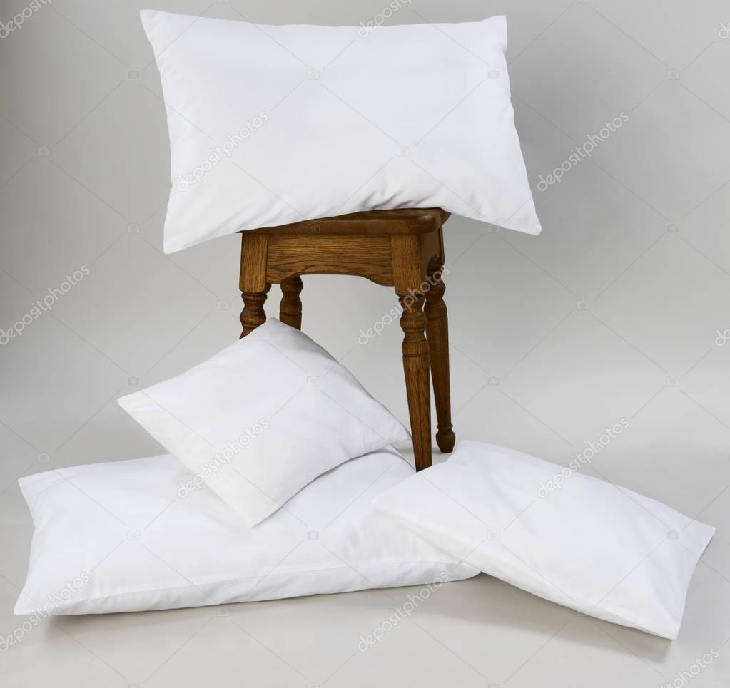 Composition of white pillows, isolated, on a gray background.