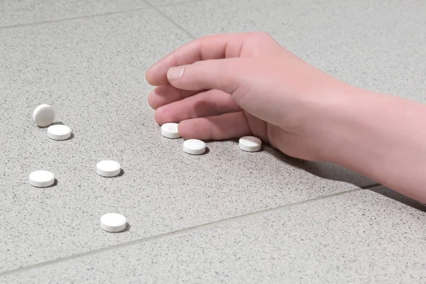 Hand with pills on the floor — Stock Photo, Image