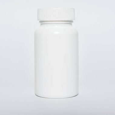 Küçük beyaz şişe kapaklı, izole, yakın çekim.