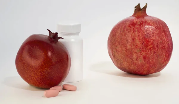 White vial, vitamins, pomegranate garnet and real garnet. — Stock Photo, Image