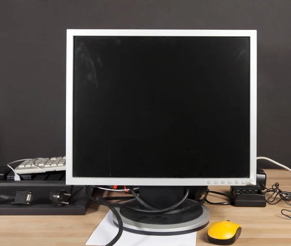 Monitor sujo, teclado, carregador para a bateria — Fotografia de Stock