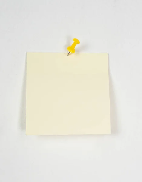 Желтая наклейка на белой стене — стоковое фото