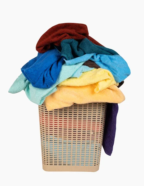 Prádelna koš s hromadou ručníků izolovaných na bílém pozadí — Stock fotografie