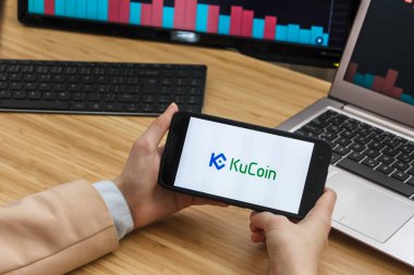 San Francisco, ABD - 18.10.2019: Kucoin Kripto Döviz Borsası Uygulamasını Kullanarak Akıllı Telefon Elleri Tutuyor. Kripto Para Birimi Geçmişi Konsepti, San Francisco, California, Usa