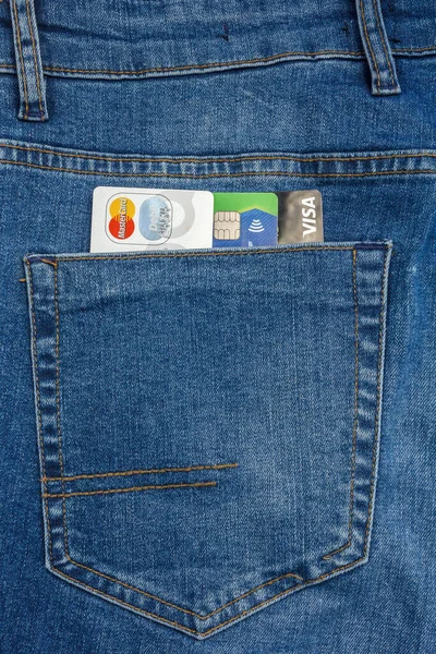 Vista de cerca a las tarjetas de crédito y débito que sobresalen de un bolsillo azul Jeans —  Fotos de Stock