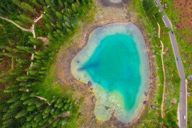 Alplerdeki Carezza Gölü 'nün turkuaz mavi sularının havadan görünüşü. Lago di Karersee köknar ağacı ormanının yanında..