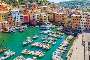 Camogli 'nin havadan görünüşü. Ligurian sahilinin yakınındaki renkli binalar. Yeşil mavi suyla marinada demirlemiş tekneler ve yatlarla yukarıdan manzara.