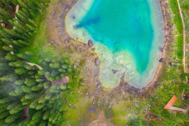 Alplerdeki Carezza Gölü 'nün turkuaz mavi sularının havadan görünüşü. Lago di Karersee köknar ağacı ormanının yanında..