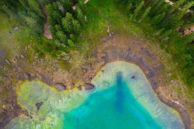 Alplerdeki Carezza Gölü 'nün turkuaz mavi sularının havadan görünüşü. Lago di Karersee köknar ağacı ormanının yanında..