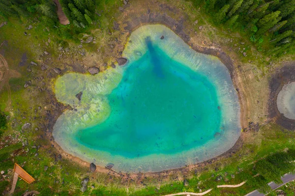 Luchtfoto van turquoise blauw water van het Carezza meer in de Alpen Dolomieten. Lago di Karersee bij dennenbos. — Stockfoto