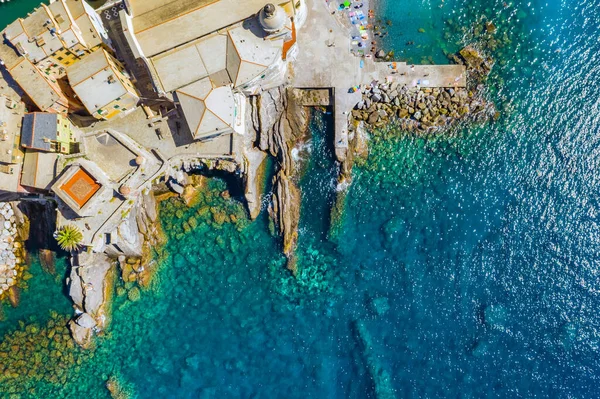 Luchtfoto van Camogli. Kasteel della Dragonara in de buurt van het Ligurische strand. Uitzicht van bovenaf op rots en zee met transparant turquoise schoon water en stenen op de bodem. — Stockfoto