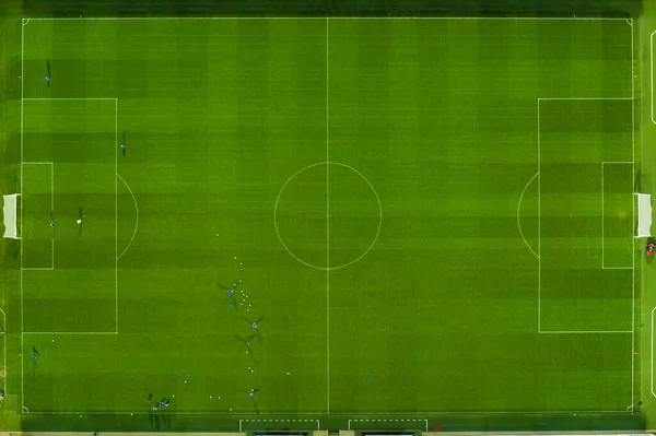 Vista aérea del campo de fútbol o fútbol mientras los atletas o jugadores están entrenando por la noche bajo luces brillantes del estadio —  Fotos de Stock