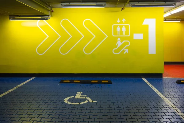 Reservado aparcamiento azul para personas con discapacidad. Símbolo internacional para discapacitados pintado en un estacionamiento del centro comercial . —  Fotos de Stock