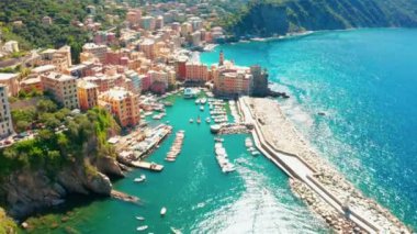 Camogli limanının havadan görüntüsü. İtalya 'nın ligurian sahili yakınlarındaki renkli binalar. Yeşil mavi suyla marinada demirlemiş tekneler ve yatlarla yukarıdan manzara.