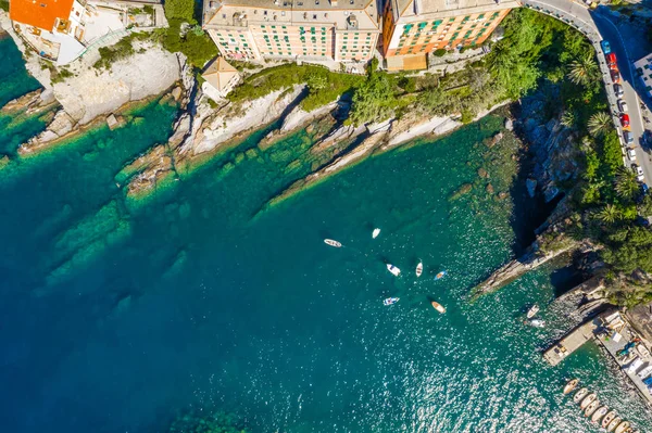 Camogli rotsachtige kust uitzicht vanuit de lucht. Boten en jachten afgemeerd in de buurt van de haven met groen water. — Stockfoto