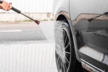 Bir adam oto yıkamada araba yıkıyor yüksek basınçlı araç yıkama makinesi suyla temizleniyor. Araba yıkama malzemeleri, Mlada Boleslav, 10.12.2019