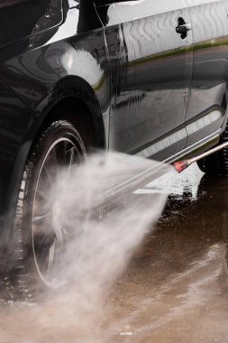 Bir adam oto yıkamada araba yıkıyor yüksek basınçlı araç yıkama makinesi suyla temizleniyor. Araba yıkama malzemeleri, Mlada Boleslav, 10.12.2019