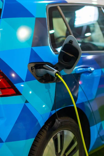 Carga de un coche eléctrico o híbrido PHEV con el cable de alimentación enchufado. Estación de carga de coche eléctrico — Foto de Stock