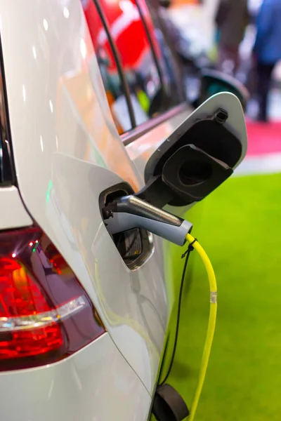 Carga de un coche eléctrico o híbrido PHEV con el cable de alimentación enchufado. Estación de carga de coche eléctrico — Foto de Stock