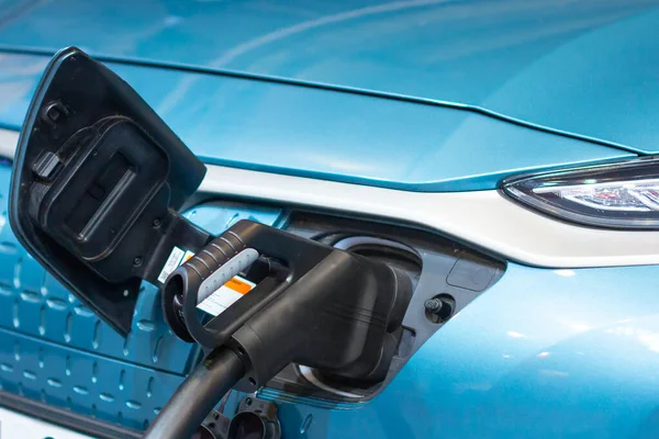 Carga de un coche eléctrico o híbrido PHEV con el cable de alimentación enchufado. Estación de carga de coche eléctrico — Foto de Stock