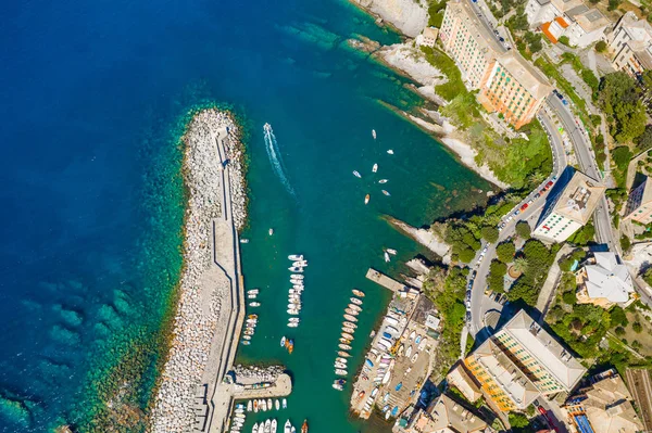 Camogli Harbor uitzicht vanuit de lucht. Kleurrijke gebouwen, boten en jachten afgemeerd in jachthaven met groen water. — Stockfoto