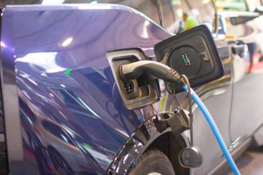 Elektrik ya da hibrit bir Phev 'e elektrik kablosu takılı olarak şarj ediliyor. Elektrikli araba şarj istasyonu. Prag, Çek Cumhuriyeti, Kasım 2019.