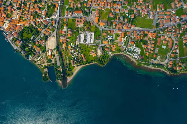 Vista aérea do lago Como, Dongo, Itália. A linha costeira é lavada por água azul-turquesa — Fotografia de Stock