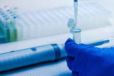 Yeni aşı sentezi ya da koronavirüse karşı ilaç. Kimyasal analiz sürecindeki klinik laboratuvarı. Otomatik pipet kullanan sonda koleksiyonu.