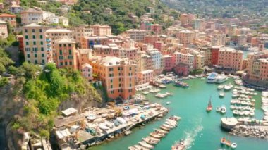 Camogli limanının havadan görüntüsü. İtalya 'nın ligurian sahili yakınlarındaki renkli binalar. Yeşil mavi suyla marinada demirlemiş tekneler ve yatlarla yukarıdan manzara.