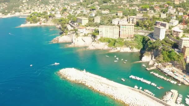 Camogli港の空中ビュー。リグーリア海のビーチ、イタリアの近くのカラフルな建物。緑の水でマリーナに係留されたボートやヨットからの眺め. — ストック動画