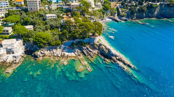 Aerial view on the city with colorful houses located on the rocky coast of ligurian sea, Camogli near Genoa, Italy. Rocky Coastline is washed by turquoise blue water. — Stok fotoğraf