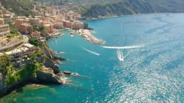Camogli limanının havadan görüntüsü. İtalya 'nın ligurian sahili yakınlarındaki renkli binalar. Yeşil mavi suyla marinada demirlemiş tekneler ve yatlarla yukarıdan manzara.