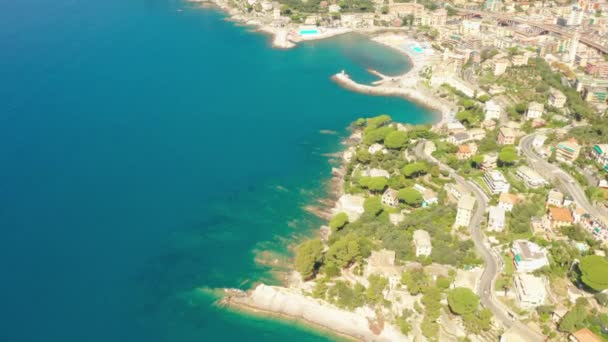 Flyg över havet med enorma stenar under det turkosblå havsvattnet. Camogli stad med traditionella färgglada hus nära Genua, Italien. — Stockvideo