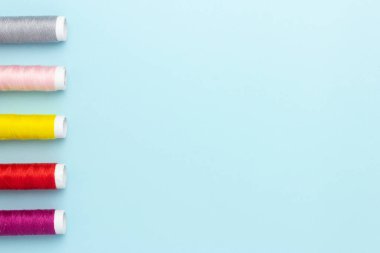 Mavi arkaplanda renkli dikiş iplikleri