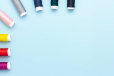 Mavi arkaplanda renkli dikiş iplikleri